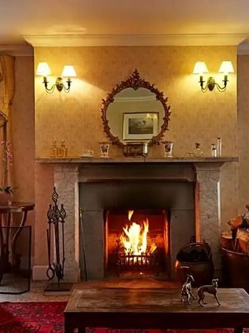 Elegantes Wohnzimmer mit brennendem Kamin und stilvollen Möbeln