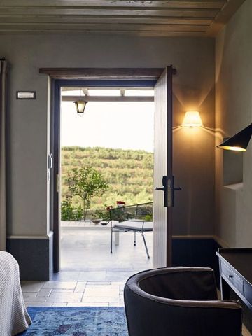Luxuriöses Hotelzimmer mit Blick auf Terrasse und grüne Landschaft