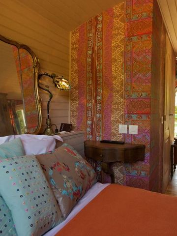 Farbenfrohes Schlafzimmer mit aufwendiger Tapete und eleganten Kissen