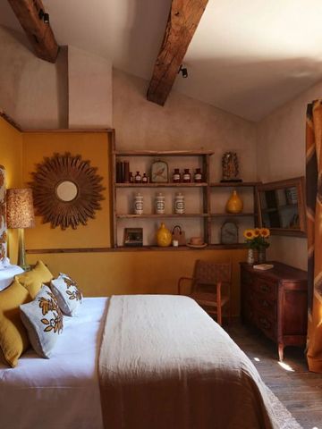 Stilvoll eingerichtetes Schlafzimmer mit Holzbalken und goldener Akzentuierung