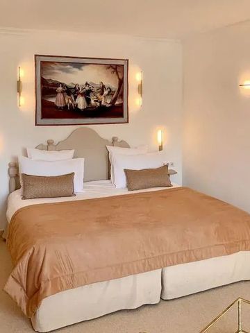 Geräumiges Zimmer mit Kunstwerk über dem Bett und stilvoller Beleuchtung