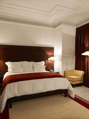 Geräumiges Hotelzimmer mit großem Bett und luxuriöser Einrichtung.