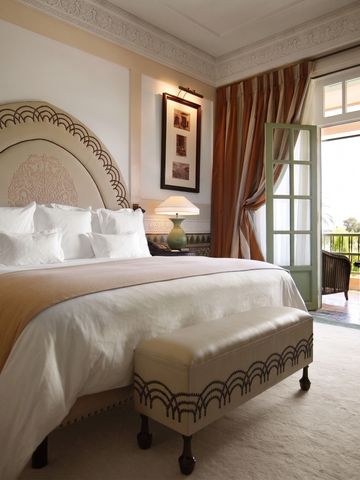 Luxuriöses Schlafzimmer mit großen Fenstern und Blick auf den Garten