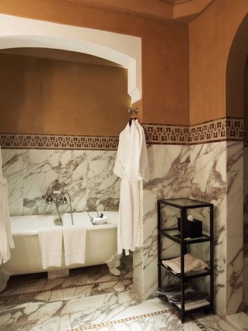 Luxuriöses Badezimmer mit freistehender Badewanne und Marmorverkleidung