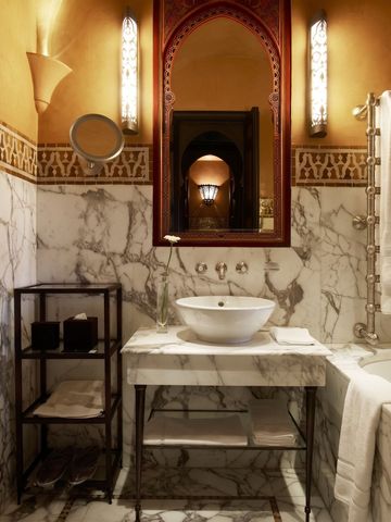 Elegantes Badezimmer mit Waschbecken, Marmorwand und kunstvollen Details