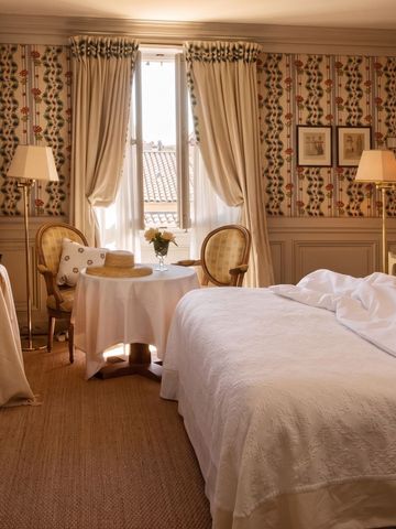 Gemütliches Hotelzimmer im rustikalen Stil mit Holzmöbeln und heller Beleuchtung