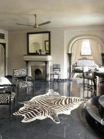 Luxuriöses Wohnzimmer mit Zebramusterteppich und stilvollen Möbeln.