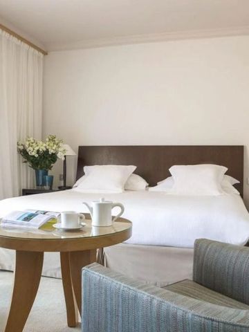 Helles Zimmer mit Doppelbett, Blumendekoration und Teeservice