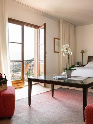 Geräumiges Zimmer mit Balkon, natürlichem Licht und komfortabler Sitzgelegenheit