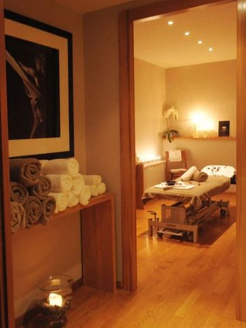 Warmes Spa mit Massagetisch, entspannender Beleuchtung und Handtüchern