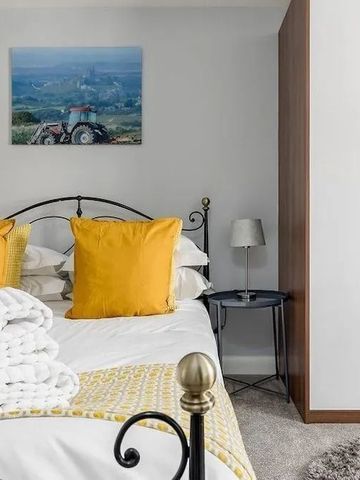 Gemütliches Schlafzimmer mit gelben Kissen und Bild an der Wand