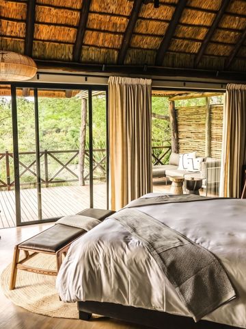 Helles Schlafzimmer mit Zugang zu einem privaten Balkon und Blick ins Grüne