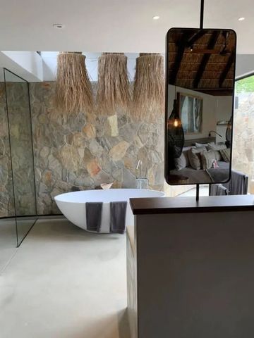Luxuriöses Badezimmer mit freistehender Badewanne und Steinwand