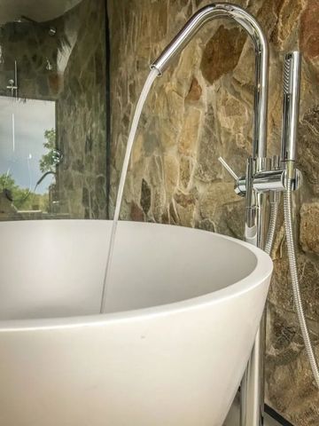 Nahaufnahme eines modernen Wasserhahns an einer freistehenden Badewanne