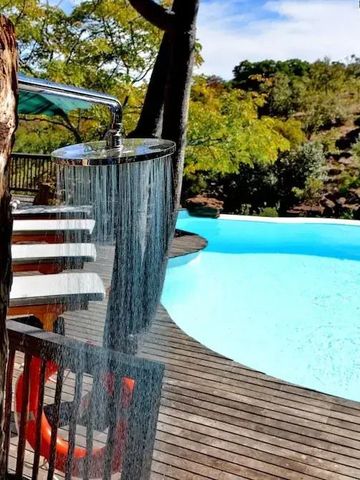 Außendusche neben Pool und Waldlandschaft