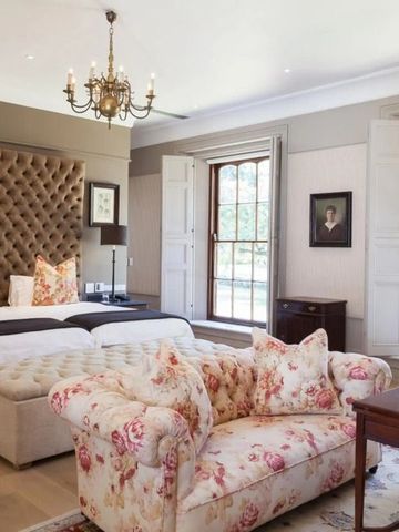 Luxuriös eingerichtetes Zimmer mit floralem Sofa und Kronleuchter
