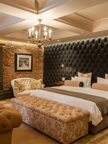 Luxuriöses Schlafzimmer mit eleganter Beleuchtung und gepolsterten Wänden