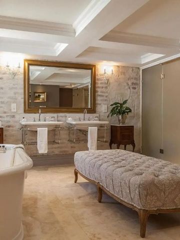 Elegantes Badezimmer mit freistehender Badewanne und gepolstertem Sitz