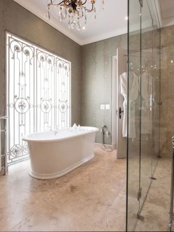 Luxuriöses Badezimmer mit freistehender Badewanne und Glasdusche