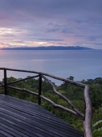 Sonnenuntergang über dem Meer mit Sicht von einer Holzterrasse.