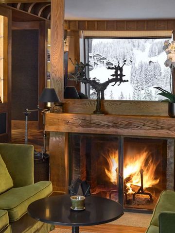 Gemütlicher Lounge-Bereich mit Kamin und Blick auf schneebedeckte Landschaft