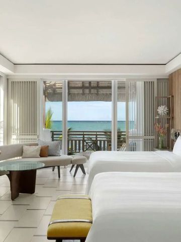 Modernes Zimmer mit großem Fenster und Meerblick am Strand.