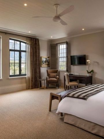 Luxuriöses Schlafzimmer mit bequemer Sitzgelegenheit und großem Bett