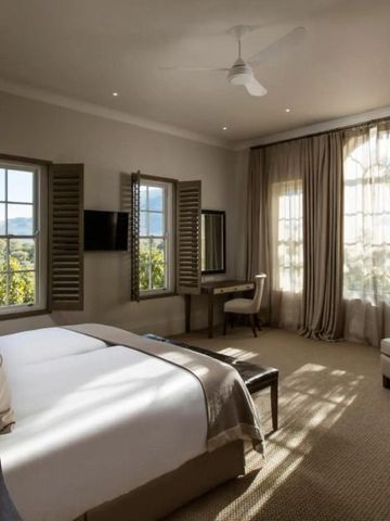Elegantes Schlafzimmer mit zwei Fenstern und geschmackvoller Dekoration