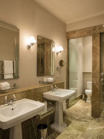 Modernes Badezimmer mit edler Marmorverkleidung und großzügiger Dusche