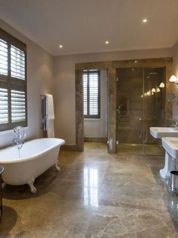 Geräumiges Badezimmer mit freistehender Badewanne und Regendusche