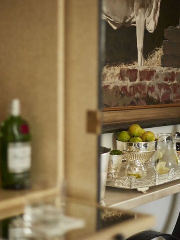 Elegante Hausbar mit verschiedenen Spirituosen und einem Gemälde im Hintergrund