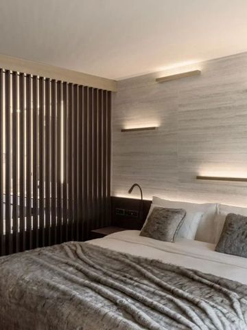 Modernes Schlafzimmer mit weichem Bett und dezenter Beleuchtung