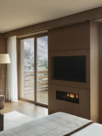 Luxuriöses Hotelzimmer mit Blick auf verschneite Berge und Kamin