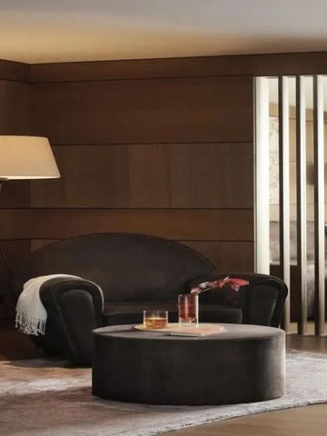 Elegante Lounge mit dunklen Sesseln und stimmungsvollem Licht