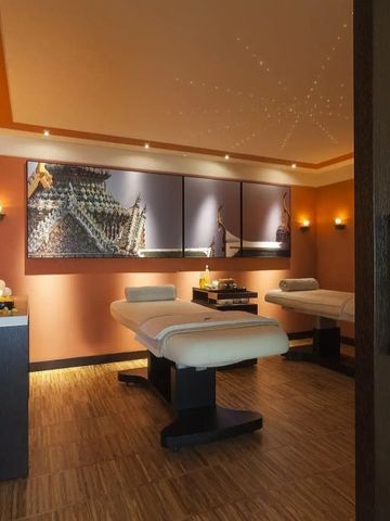 Gemütlicher Spa-Raum mit zwei Massageliegen und beruhigender Beleuchtung