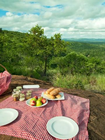 Picknickplatz mit Decke und Aussicht auf grüne Hügel