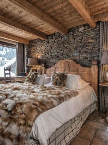 Luxuriöses Schlafzimmer mit Pelzüberwurf und Blick auf schneebedeckte Landschaft