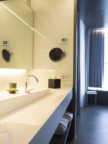 Modernes Badezimmer mit großem Spiegel und stilvollem Waschbecken.
