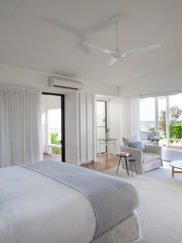 Helle Suite mit weißen Akzenten und Meerblick, Doppelbett und gemütlicher Sitzecke