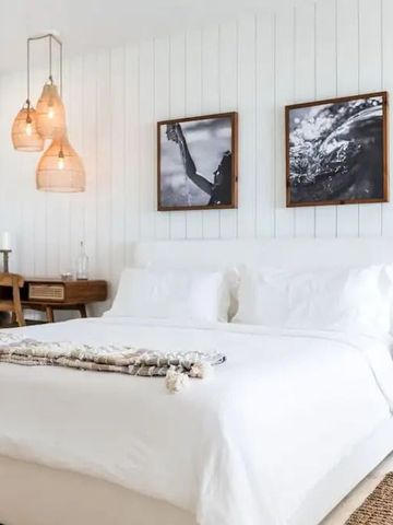 Schlafzimmer mit elegantem weißen Bett und stilvollen Dekorationen
