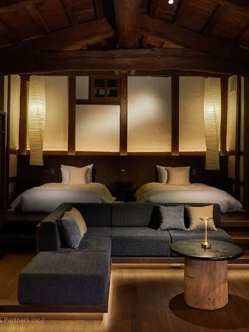 Luxuriöses Hotelzimmer mit Holzbalken und stilvollen Möbeln in warmem Ambiente