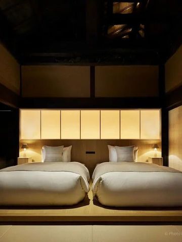 Moderner japanischer Raum mit zwei Betten und sanfter Beleuchtung in minimalistischer Gestaltung