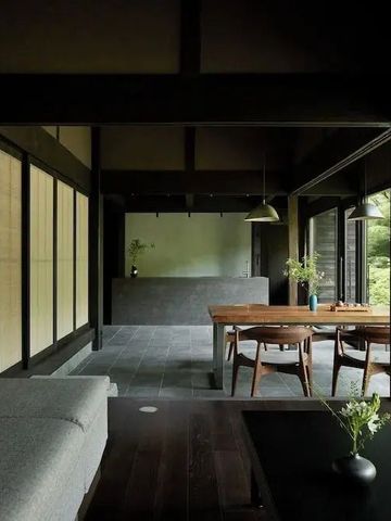 Offener Wohnbereich mit großem Fenster und elegantem Holztisch im Zen-Stil