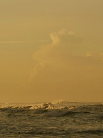 Sanfte Wellen des Meeres im warmen Abendlicht bei ruhiger See