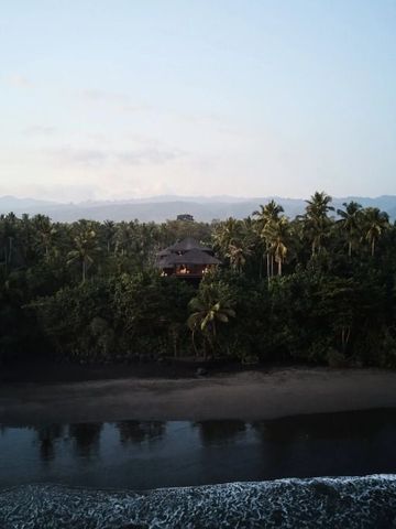 Villa im dichten Regenwald mit Blick auf einsamen Strand