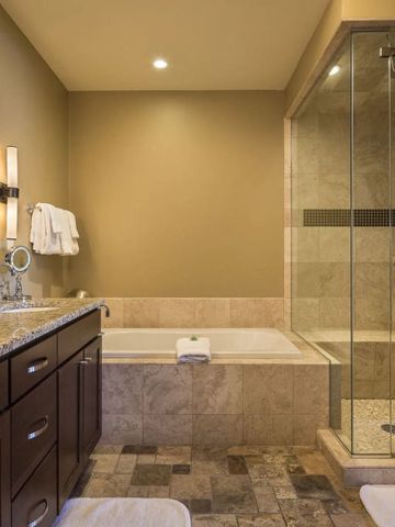 Modernes Bad mit Dusche und Badewanne im luxuriösen Design im Lumiere by Dunton Hotel