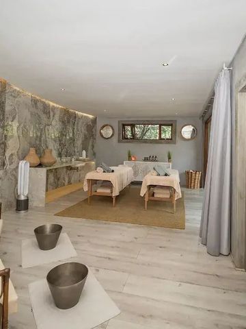Massagezimmer mit zwei Liegen und stilvoller Dekoration.