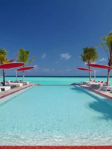 Infinity Pool mit Blick auf das Meer und Palmen