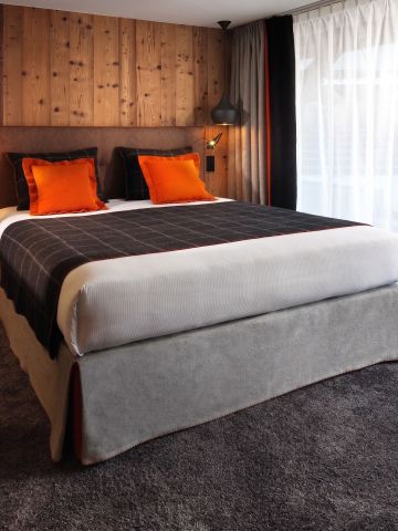 Gemütliches Doppelzimmer mit Teppichboden und Holzwandverkleidung