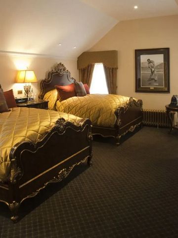 Doppelzimmer mit luxuriösen Betten und klassischem Dekor.